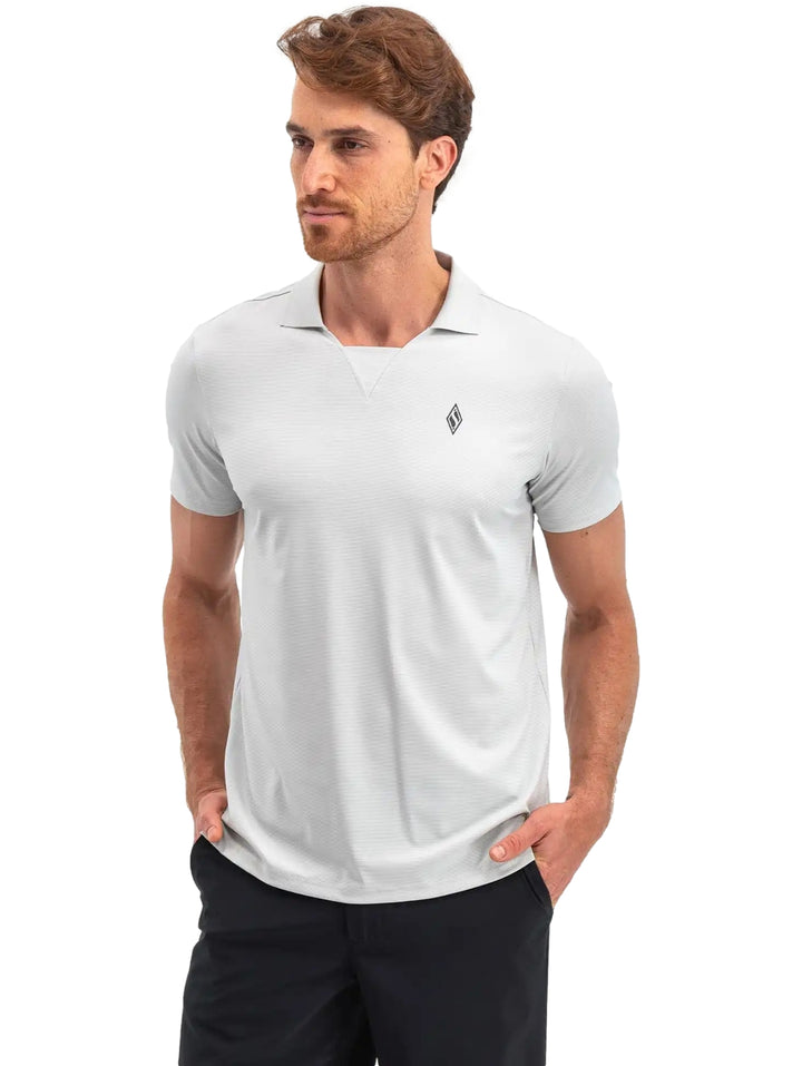 Hombre vistiendo una polo Skechers de color gris claro con cuello y manga corta.