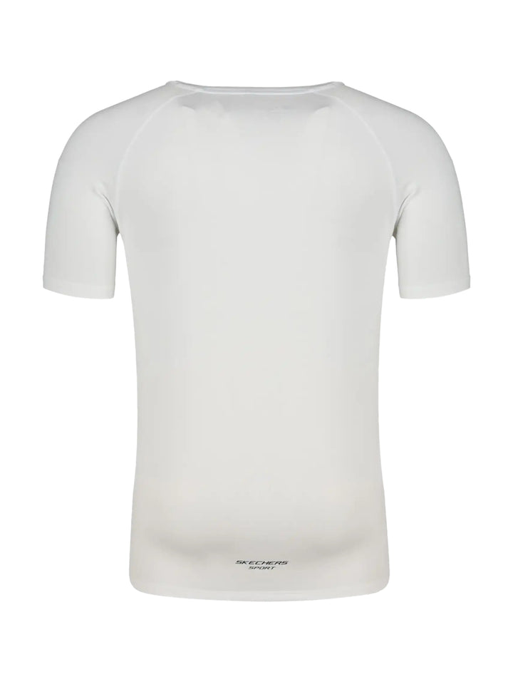 Hombre vistiendo una playera deportiva blanca de manga corta marca Skechers.