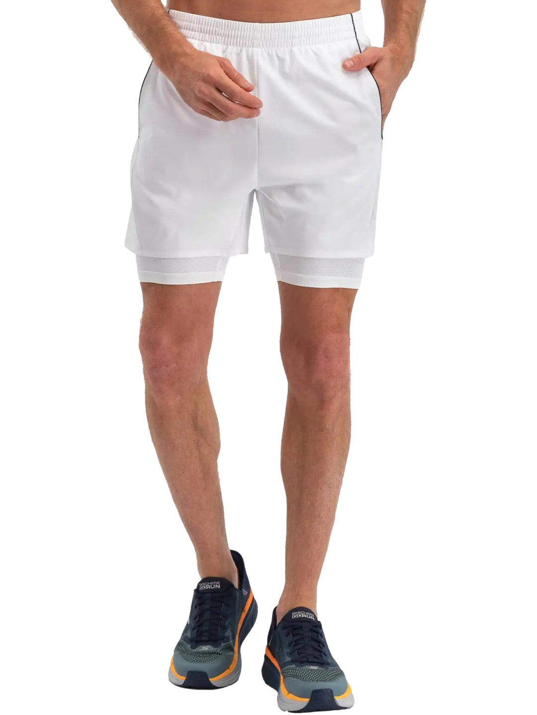 Hombre vistiendo shorts deportivos blancos de Skechers con forro interno ajustado.