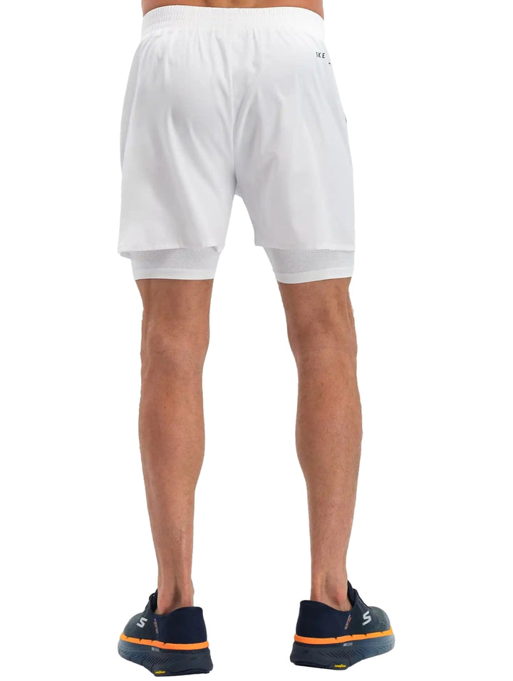 Hombre vistiendo shorts deportivos blancos de Skechers con forro interno ajustado.