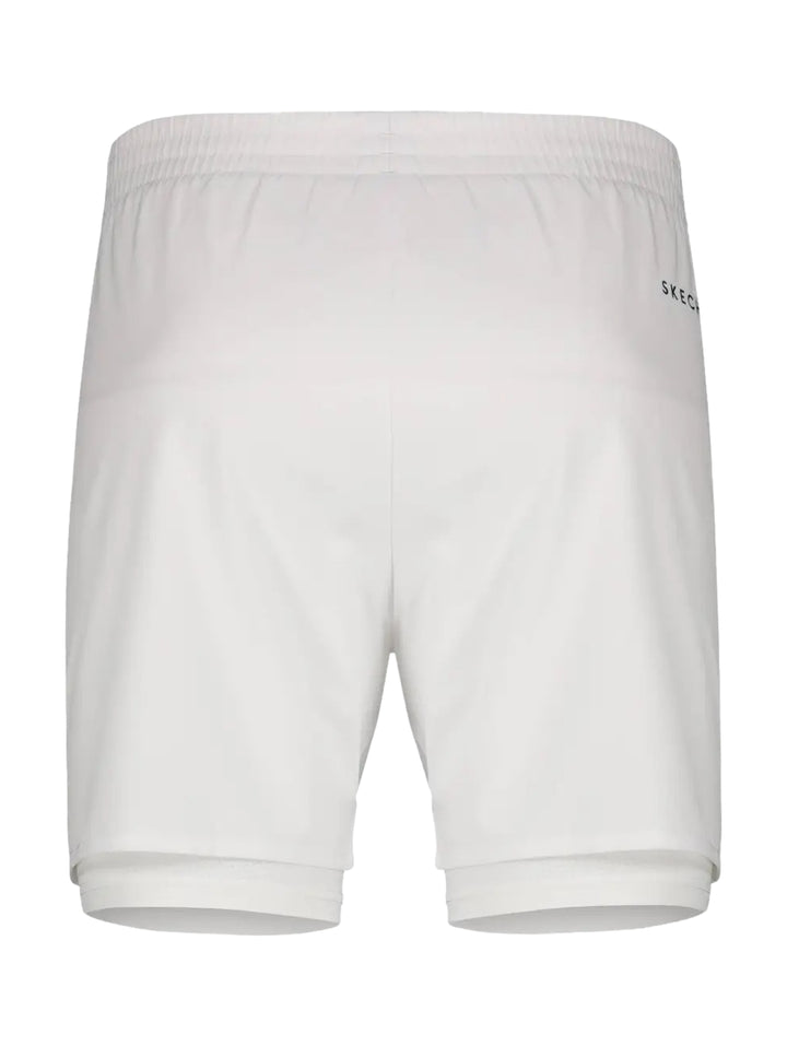 Hombre vistiendo shorts deportivos blancos de Skechers con forro interno ajustado.