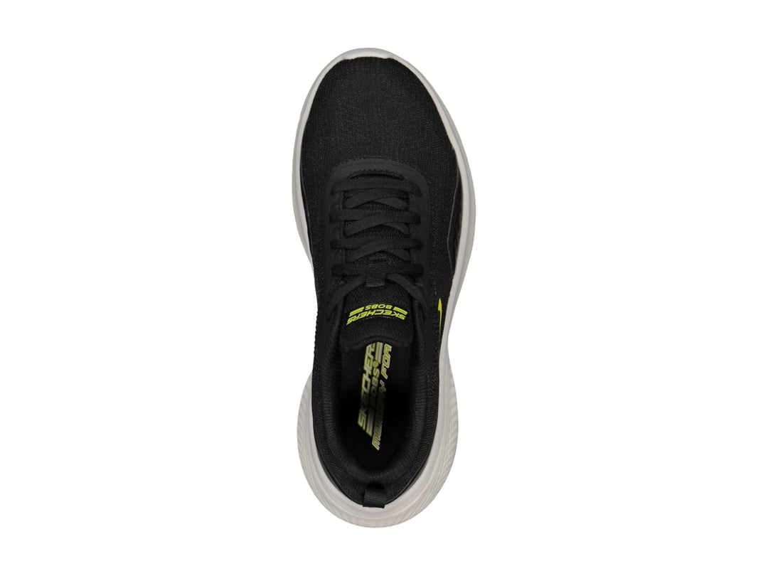 Tenis deportivos Skechers color negro con suela blanca y logotipo amarillo en el lateral.