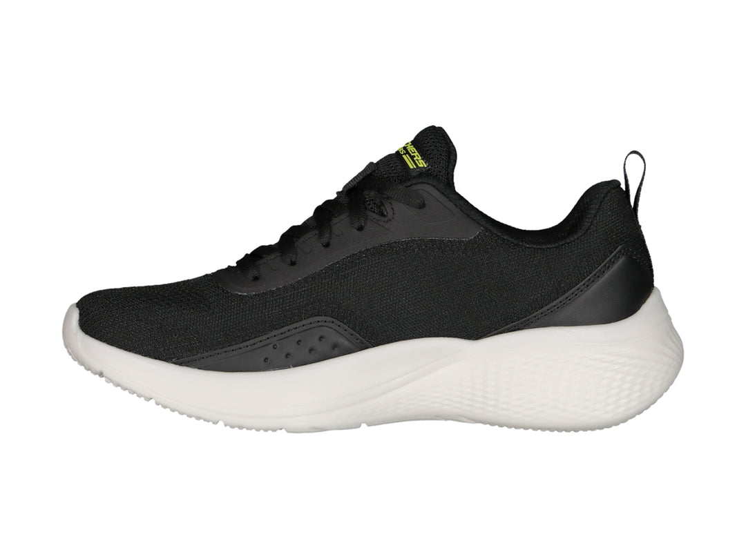Tenis deportivos Skechers color negro con suela blanca y logotipo amarillo en el lateral.