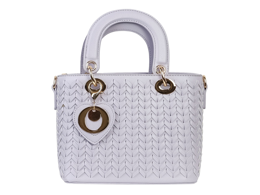 Bolso de mano color púrpura claro con diseño tejido, asa superior y detalle decorativo en forma de corazón dorado.