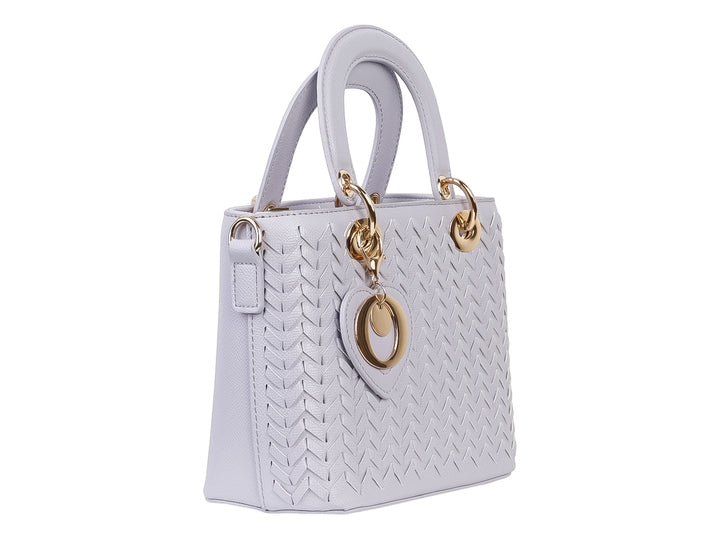 Bolso de mano color púrpura claro con diseño tejido, asa superior y detalle decorativo en forma de corazón dorado.