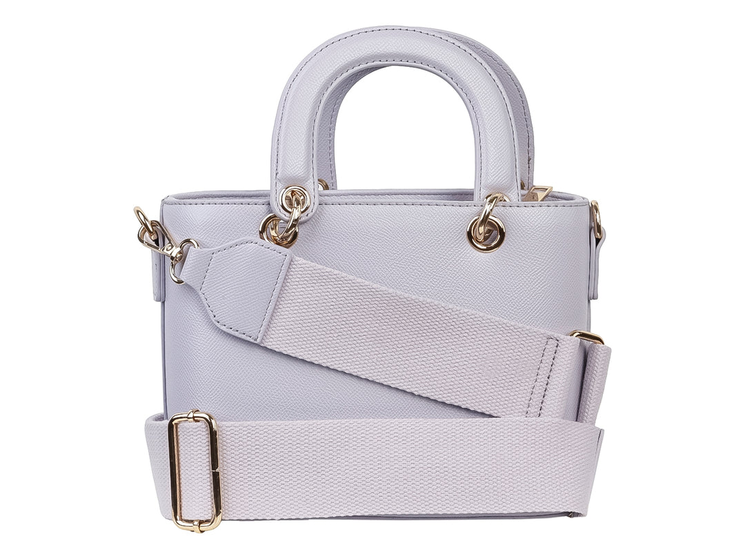 Bolso de mano color púrpura claro con diseño tejido, asa superior y detalle decorativo en forma de corazón dorado.