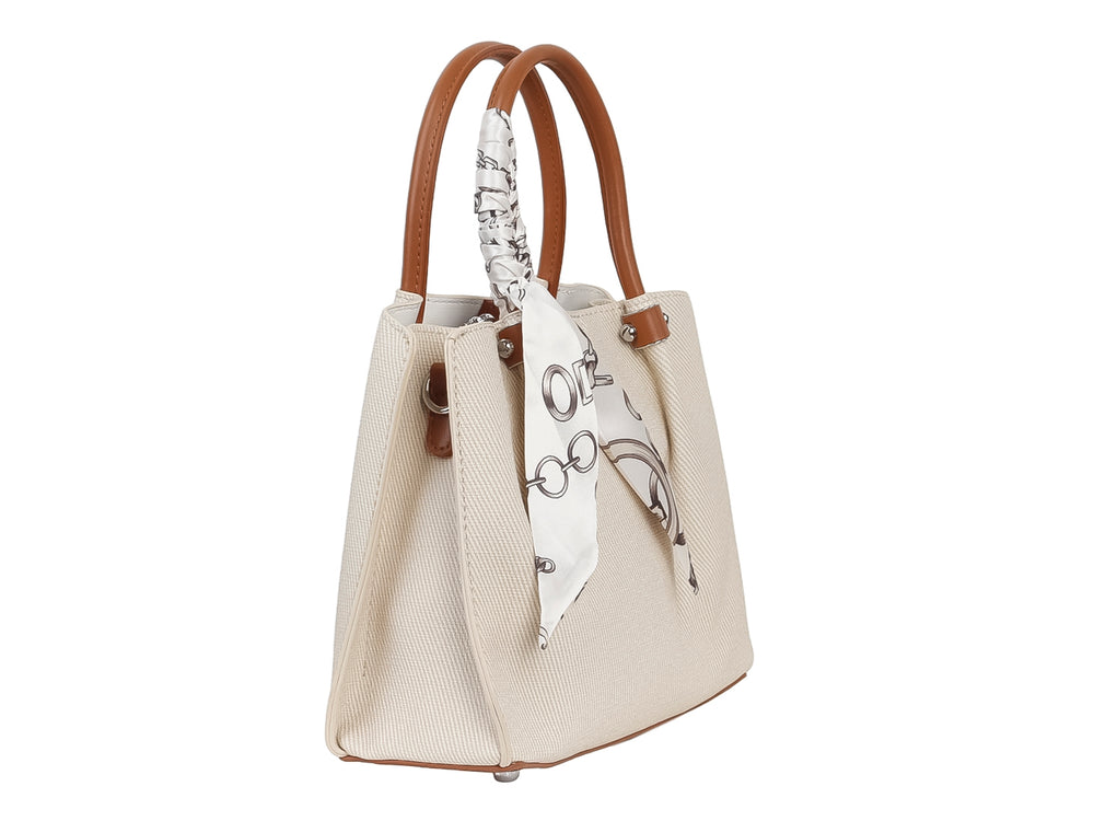 Bolso de mano color beige con asa marrón y un pañuelo blanco con estampado negro anudado al asa.