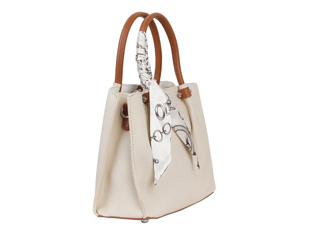 Bolso de mano color beige con asa marrón y un pañuelo blanco con estampado negro anudado al asa.