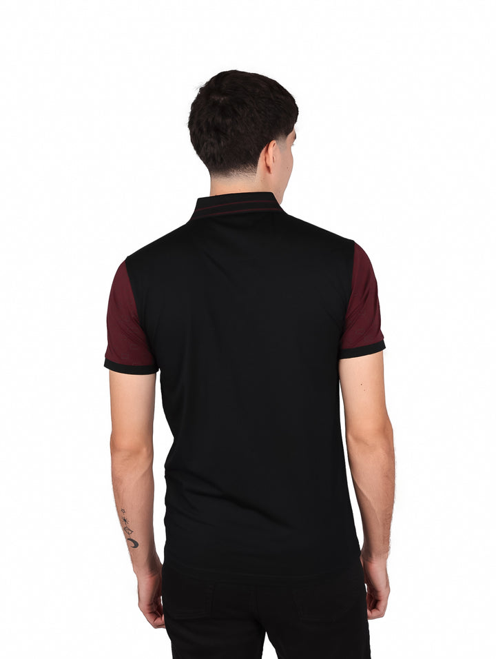 Hombre vistiendo playera polo color burgundy y negro con rayas blancas horizontales en el pecho.