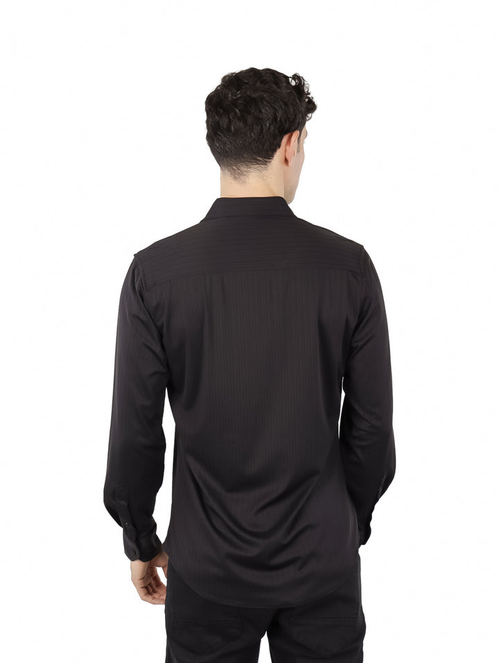 Hombre vistiendo una camisa negra de manga larga con botones y cuello.