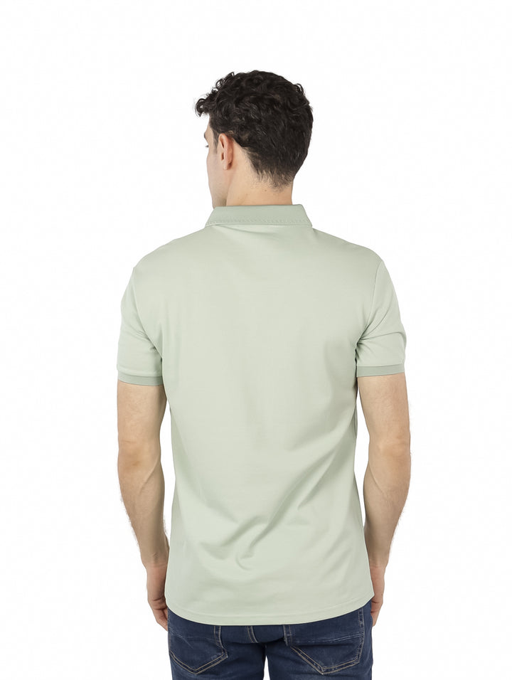 Hombre vistiendo una playera polo de color verde claro con cuello y manga corta.