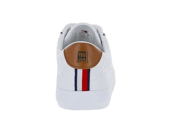 Tenis blancos Tommy Hilfiger con textura grabada, cordones blancos y detalle café en el talón.