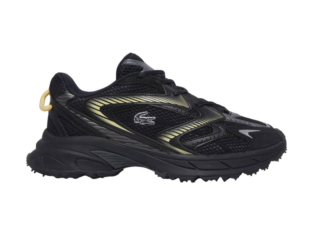Tenis deportivos Lacoste color negro con detalles en amarillo y suela gruesa.