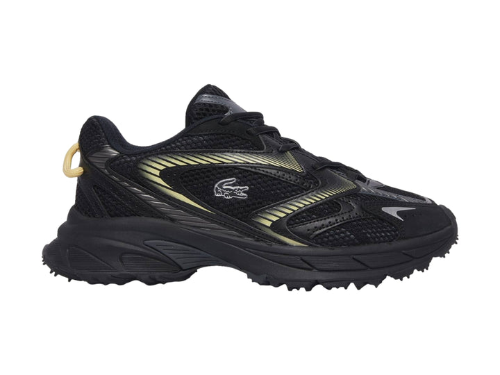 Tenis deportivos Lacoste color negro con detalles en amarillo y suela gruesa.