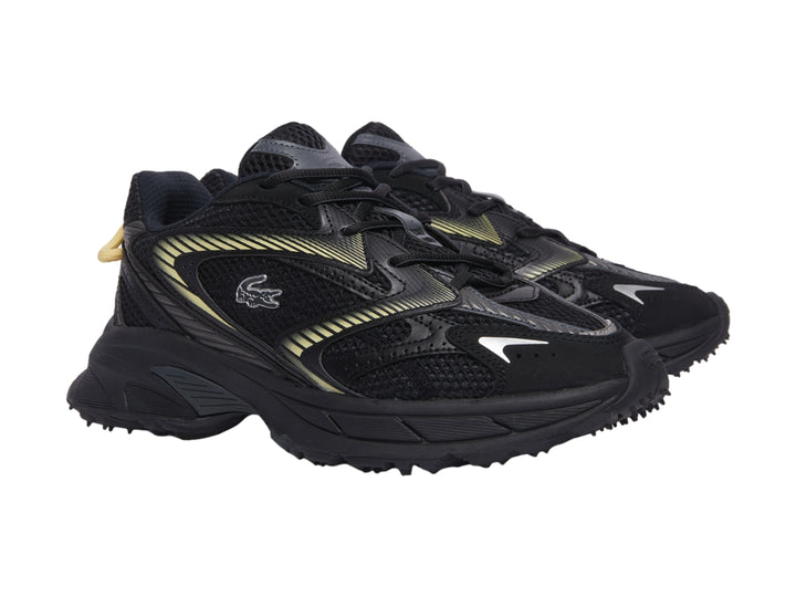 Tenis deportivos Lacoste color negro con detalles en amarillo y suela gruesa.