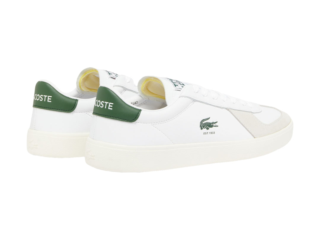 Tenis Lacoste blancos con detalles en color crema y talón verde, vista lateral.