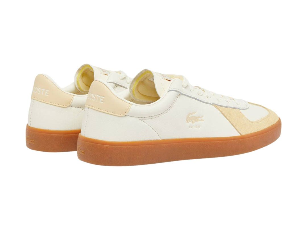 Tenis Lacoste color amarillo claro con detalles beige y suela de goma marrón.