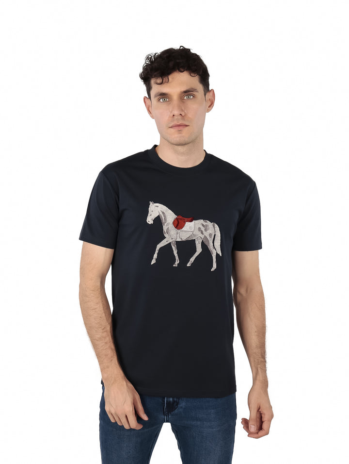 Hombre vistiendo playera color navy con estampado de un caballo blanco y rojo en el pecho.