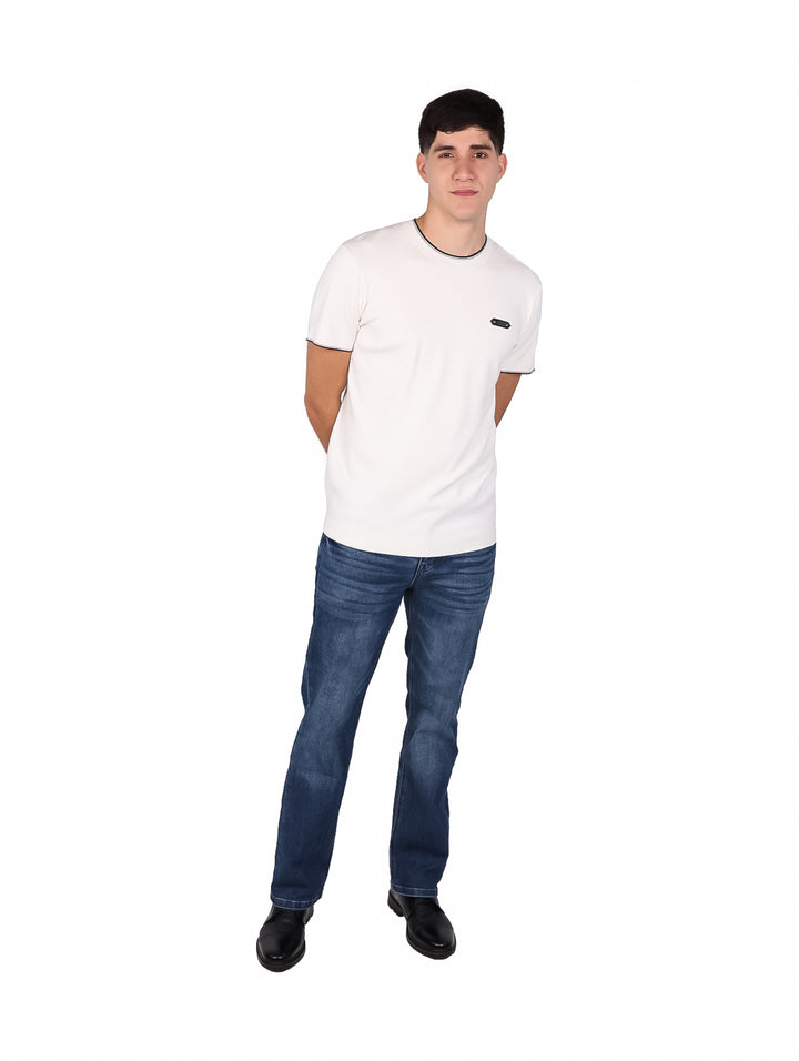 Hombre vistiendo playera blanca de manga corta con ribete negro en el cuello y las mangas.