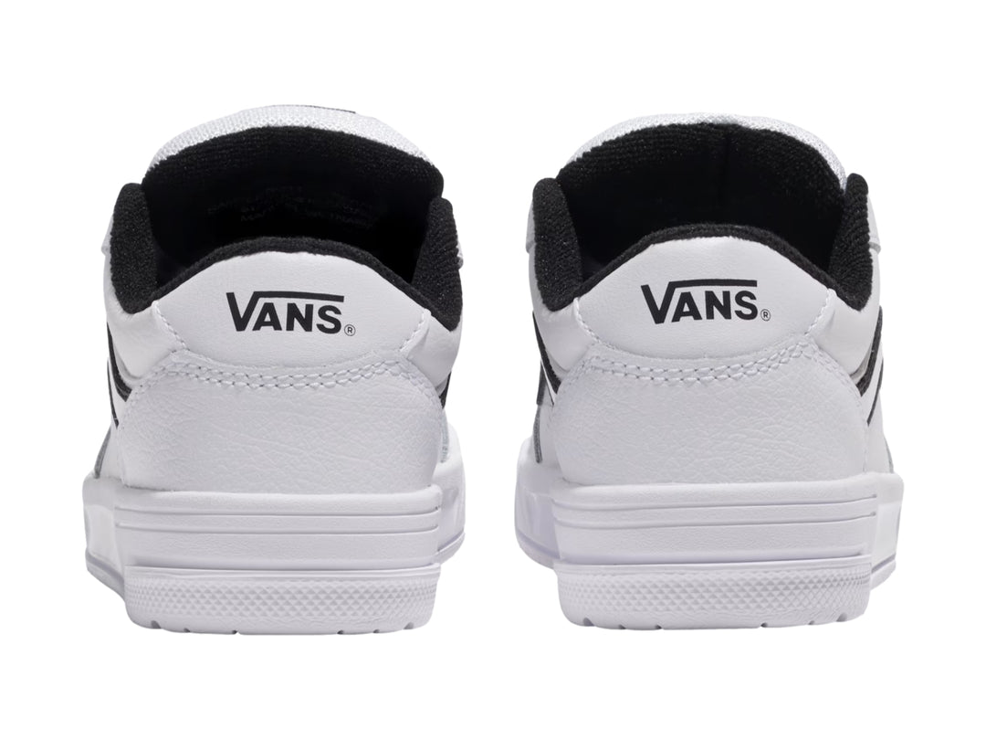 Tenis Vans blancos con franja lateral negra y suela blanca.
