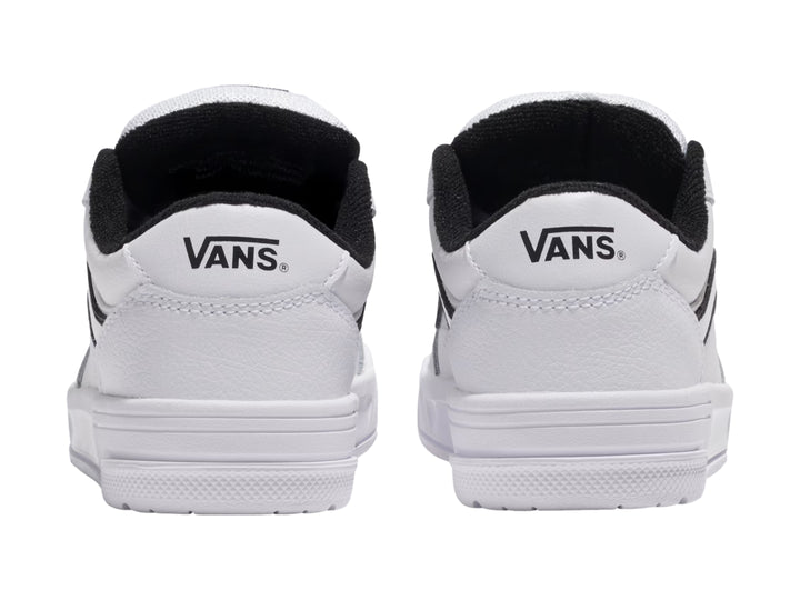 Tenis Vans blancos con franja lateral negra y suela blanca.