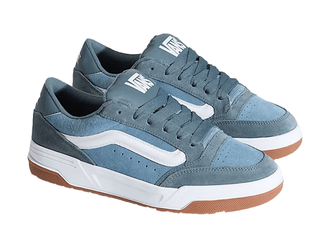 Tenis Vans Hylane color azul grisáceo con franja blanca y suela de goma marrón.
