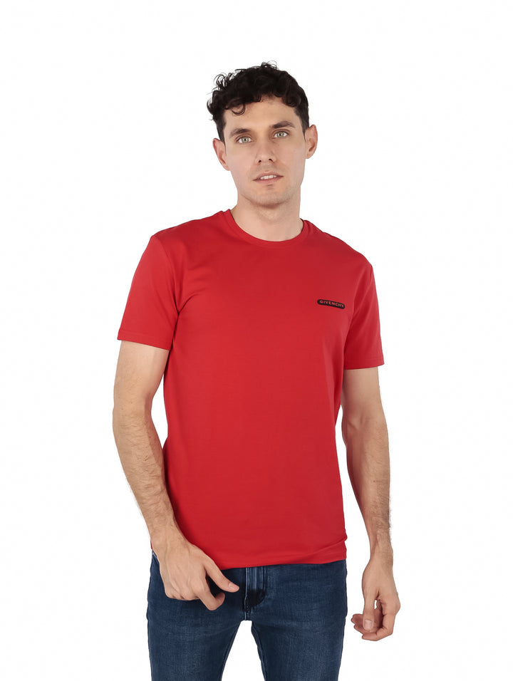 Hombre vistiendo una camiseta casual de color rojo intenso con cuello redondo y manga corta de la marca Givenchy.