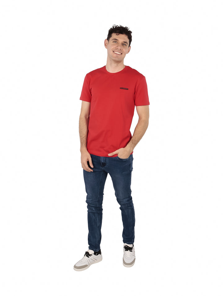 Hombre vistiendo una camiseta casual de color rojo intenso con cuello redondo y manga corta de la marca Givenchy.