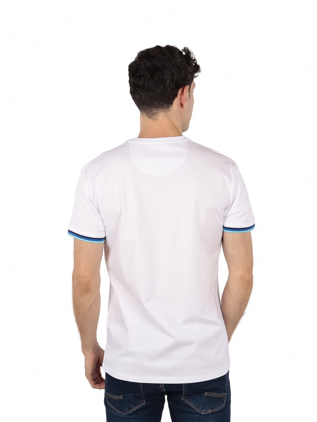 Hombre vistiendo playera blanca de manga corta con rayas en las mangas y pantalones azules.