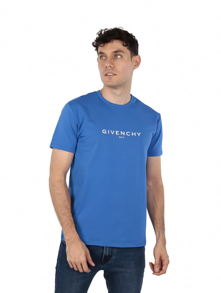 Hombre vistiendo una camiseta azul de manga corta con el logo de Givenchy en el pecho.