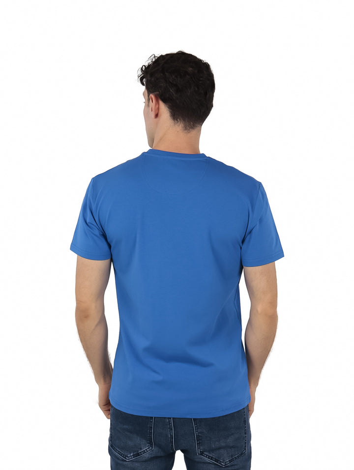 Hombre vistiendo una camiseta azul de manga corta con el logo de Givenchy en el pecho.