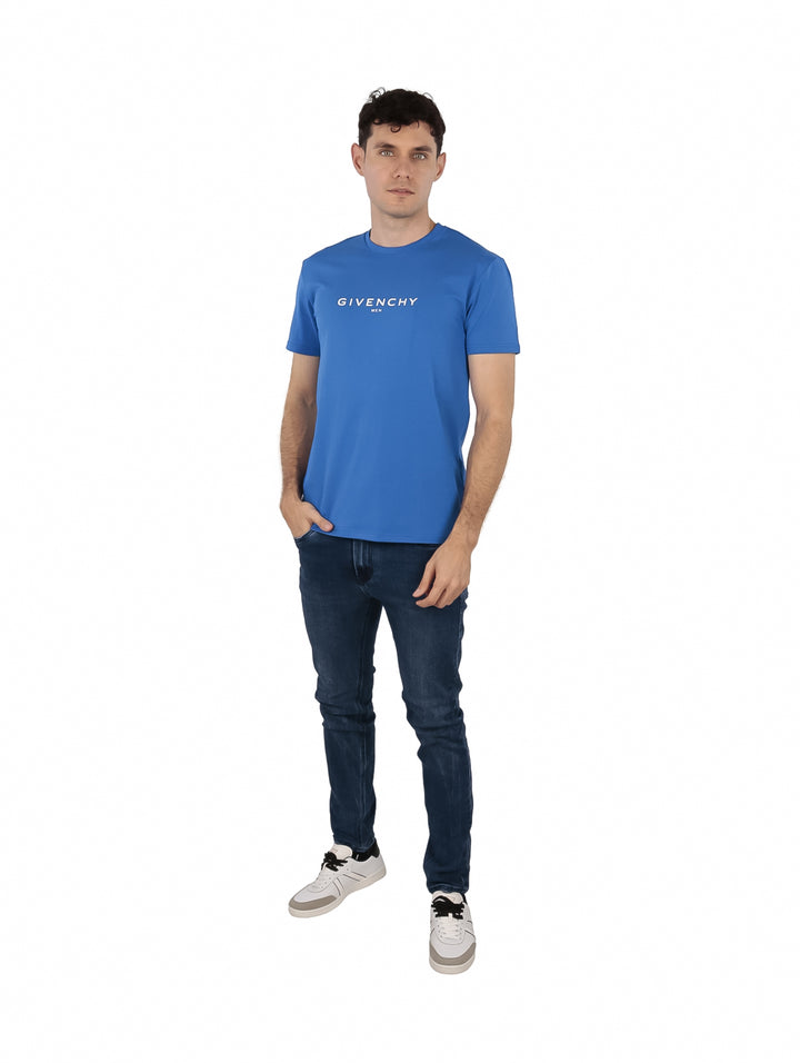 Hombre vistiendo una camiseta azul de manga corta con el logo de Givenchy en el pecho.
