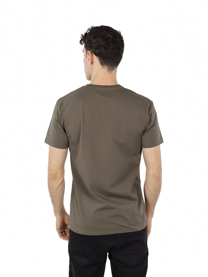 Hombre vistiendo playera Givenchy de manga corta en color oliva Chimera con logotipo frontal.