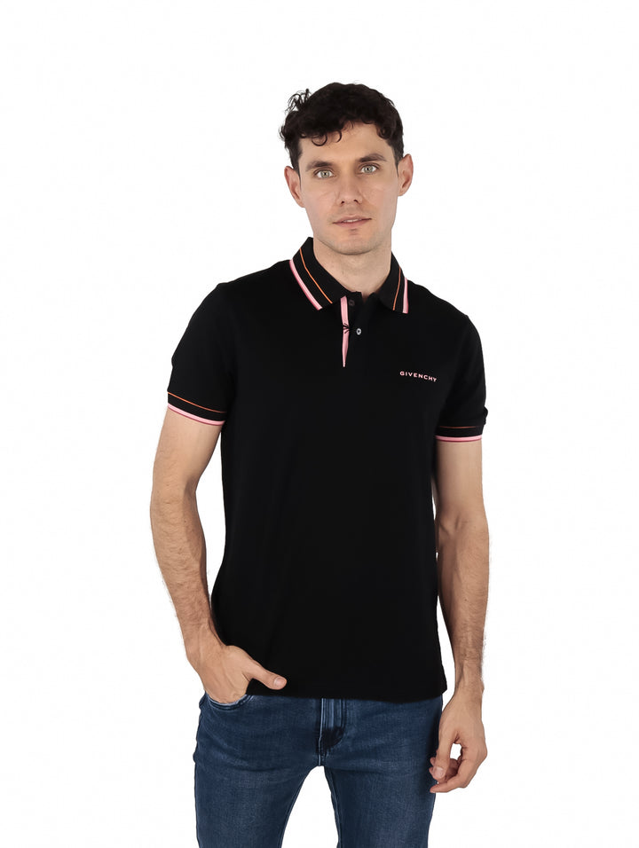 Hombre vistiendo polo Givenchy color negro con detalles en rosa en el cuello y mangas.