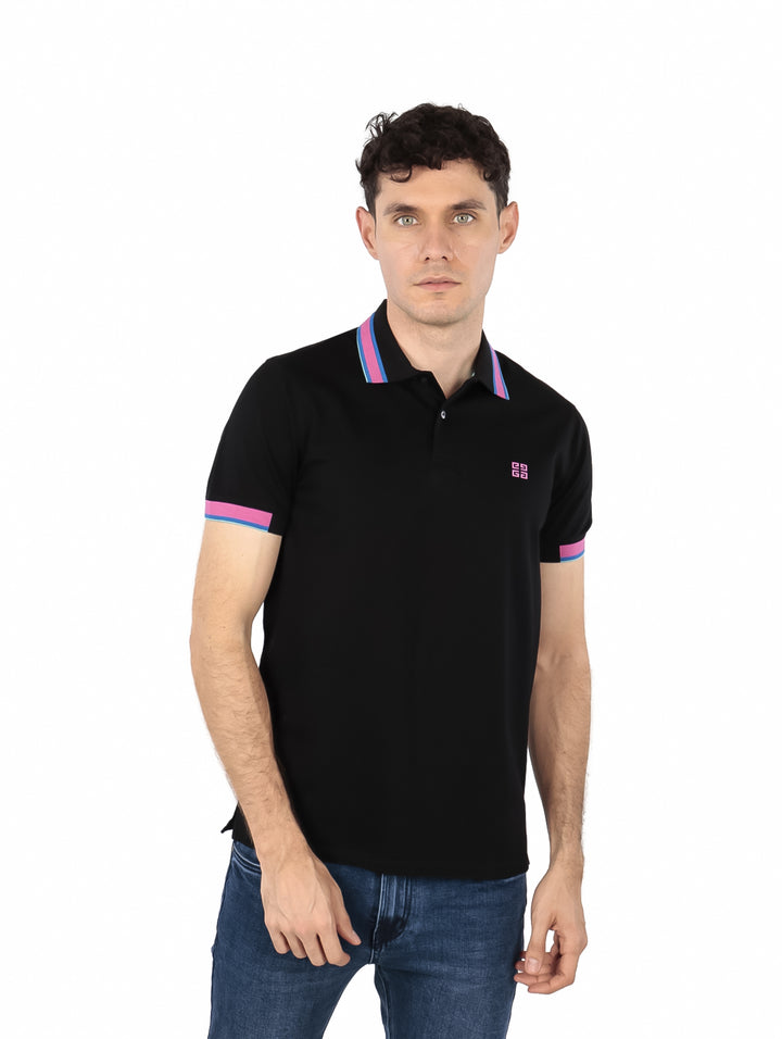 Hombre vistiendo polo negro de Givenchy con detalles en rosa y azul en el cuello y mangas.