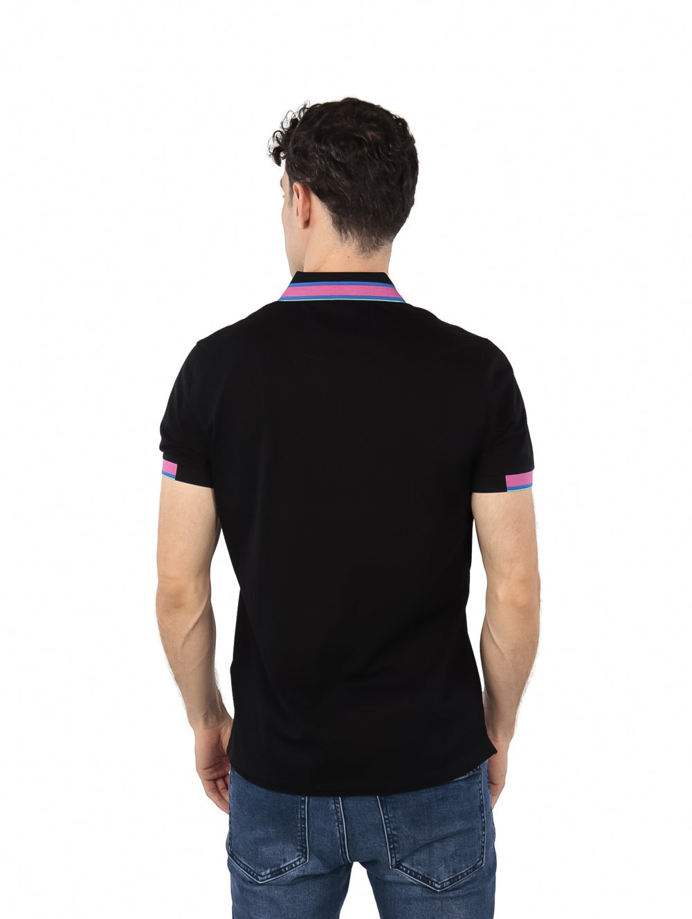 Hombre vistiendo polo negro de Givenchy con detalles en rosa y azul en el cuello y mangas.