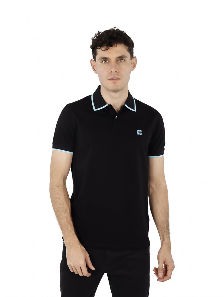 Hombre vistiendo polo negro Givenchy con detalles en celeste en cuello y mangas.