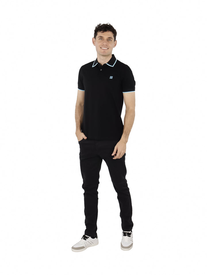 Hombre vistiendo polo negro Givenchy con detalles en celeste en cuello y mangas.