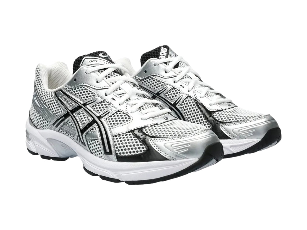 Tenis deportivos ASICS GEL-1130 color blanco y plateado con detalles negros y malla transpirable.