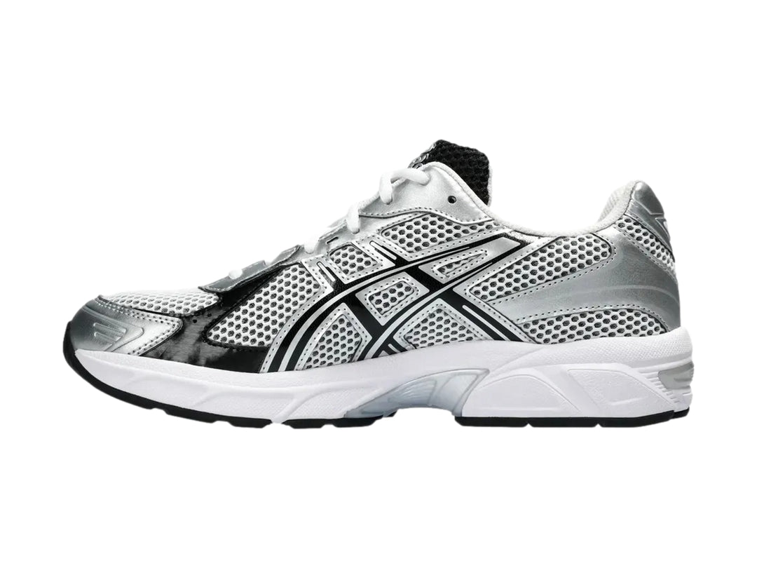 Tenis deportivos ASICS GEL-1130 color blanco y plateado con detalles negros y malla transpirable.