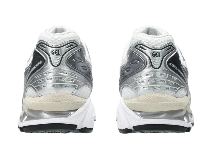 Tenis deportivos ASICS Gel-Kayano en color blanco con detalles en gris grafito y suela amortiguada.