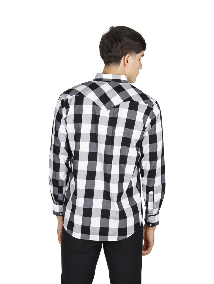 Hombre vistiendo camisa de cuadros en blanco y negro y pantalones negros sobre fondo blanco.