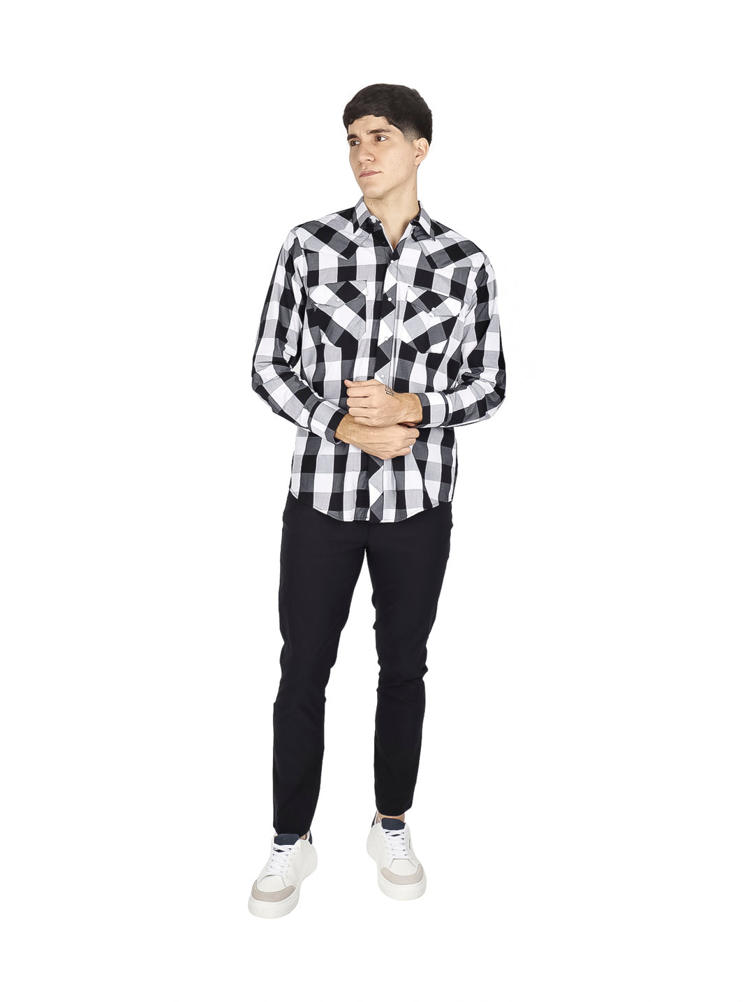 Hombre vistiendo camisa de cuadros en blanco y negro y pantalones negros sobre fondo blanco.