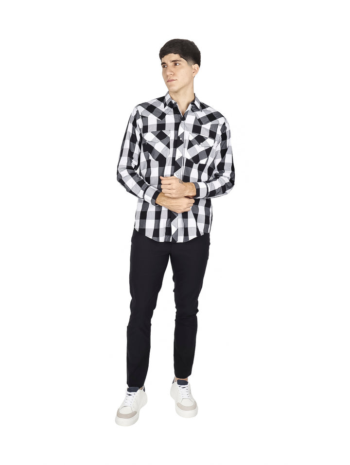 Hombre vistiendo camisa de cuadros en blanco y negro y pantalones negros sobre fondo blanco.