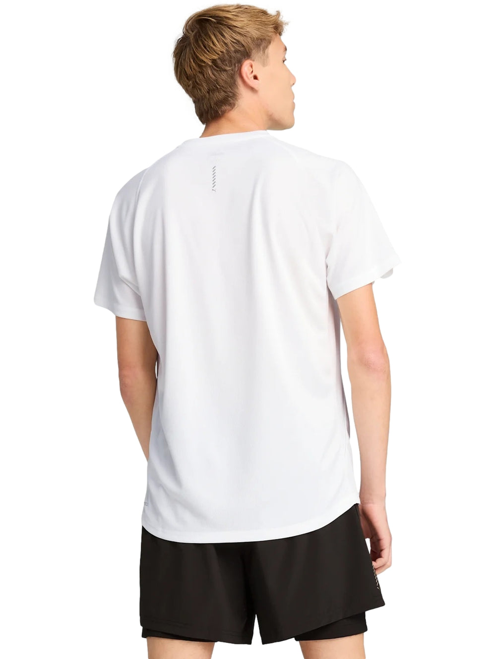 Hombre vistiendo una camiseta deportiva PUMA de color blanco con manga corta y cuello redondo.