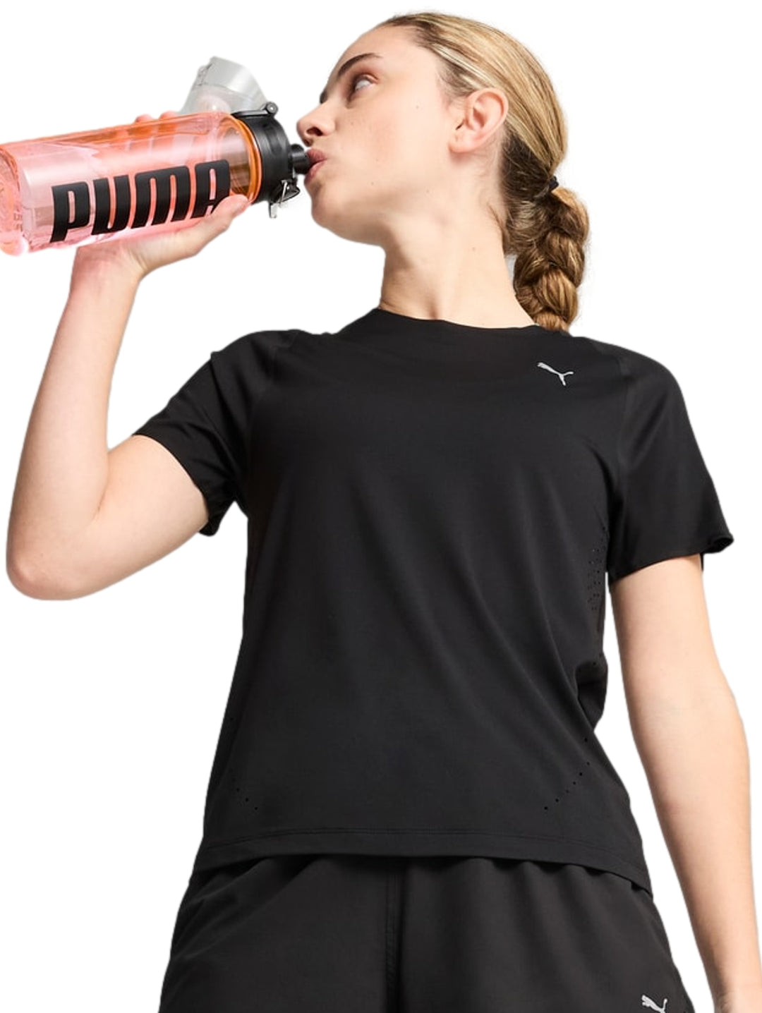 Mujer vistiendo playera deportiva Puma de color negro y manga corta.