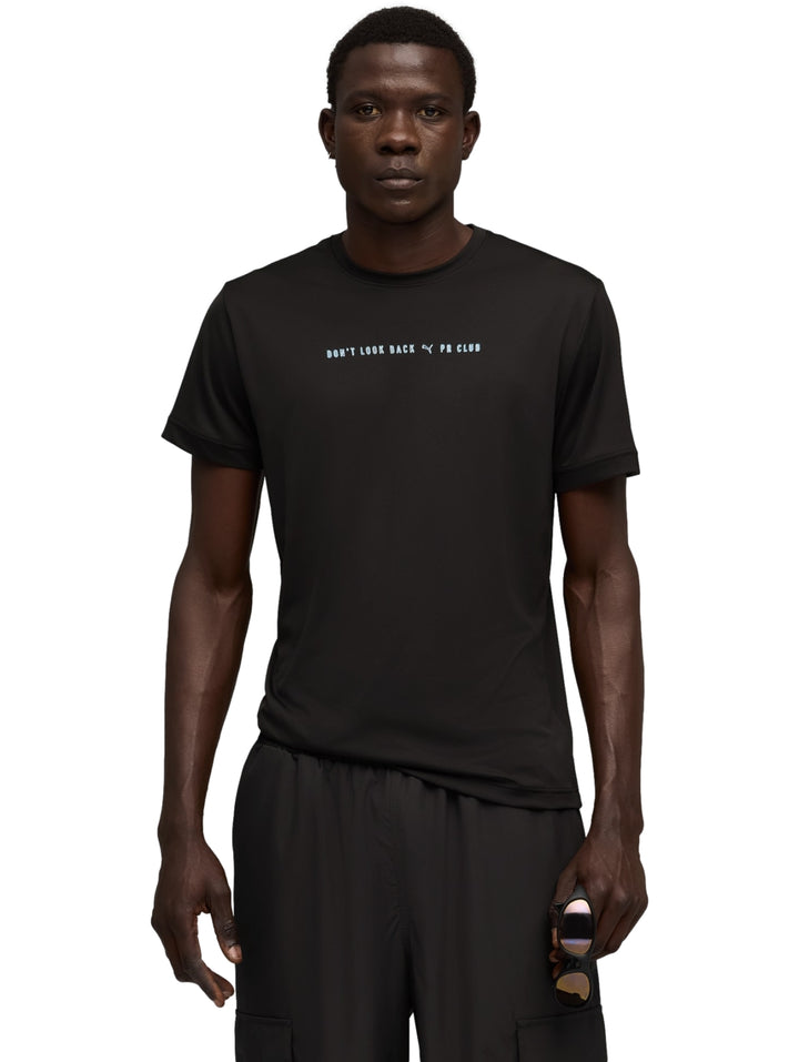 Hombre vistiendo playera deportiva Puma de color negro con gráfico pequeño en el pecho y shorts negros.