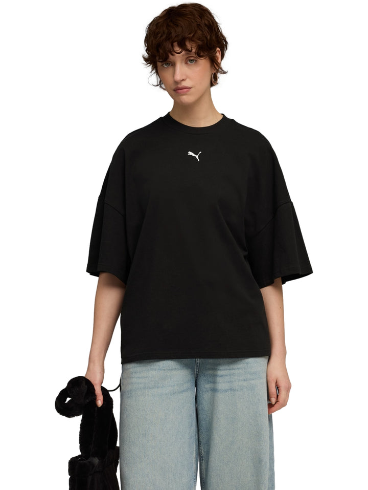 Mujer vistiendo una camiseta PUMA negra de corte oversized y cuello redondo.