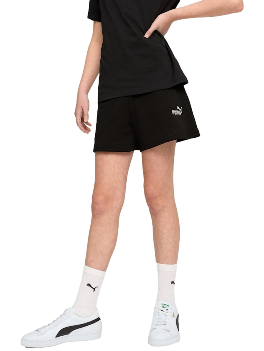 Mujer vistiendo shorts deportivos negros de marca PUMA con logo blanco lateral.