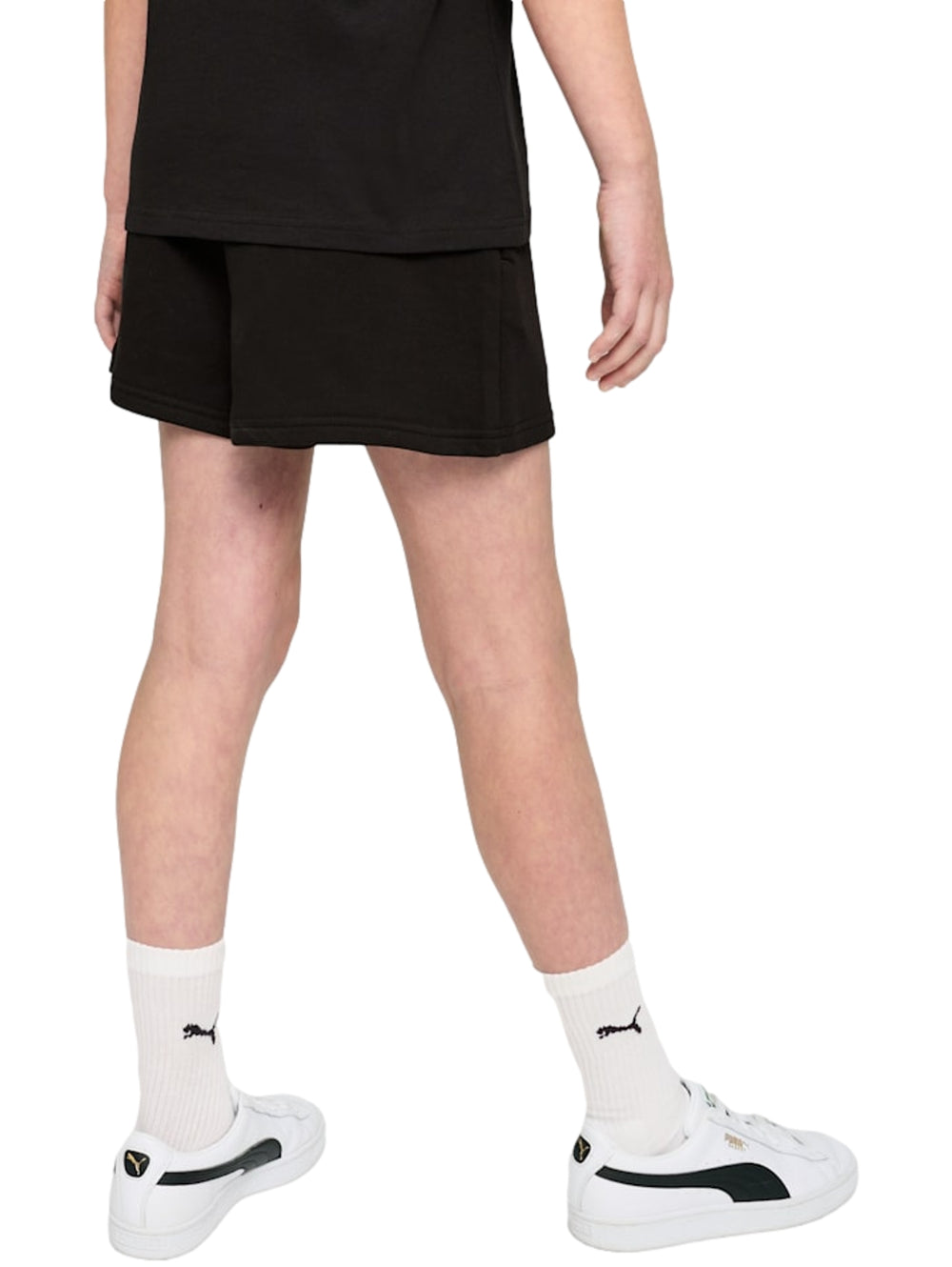 Mujer vistiendo shorts deportivos negros de marca PUMA con logo blanco lateral.